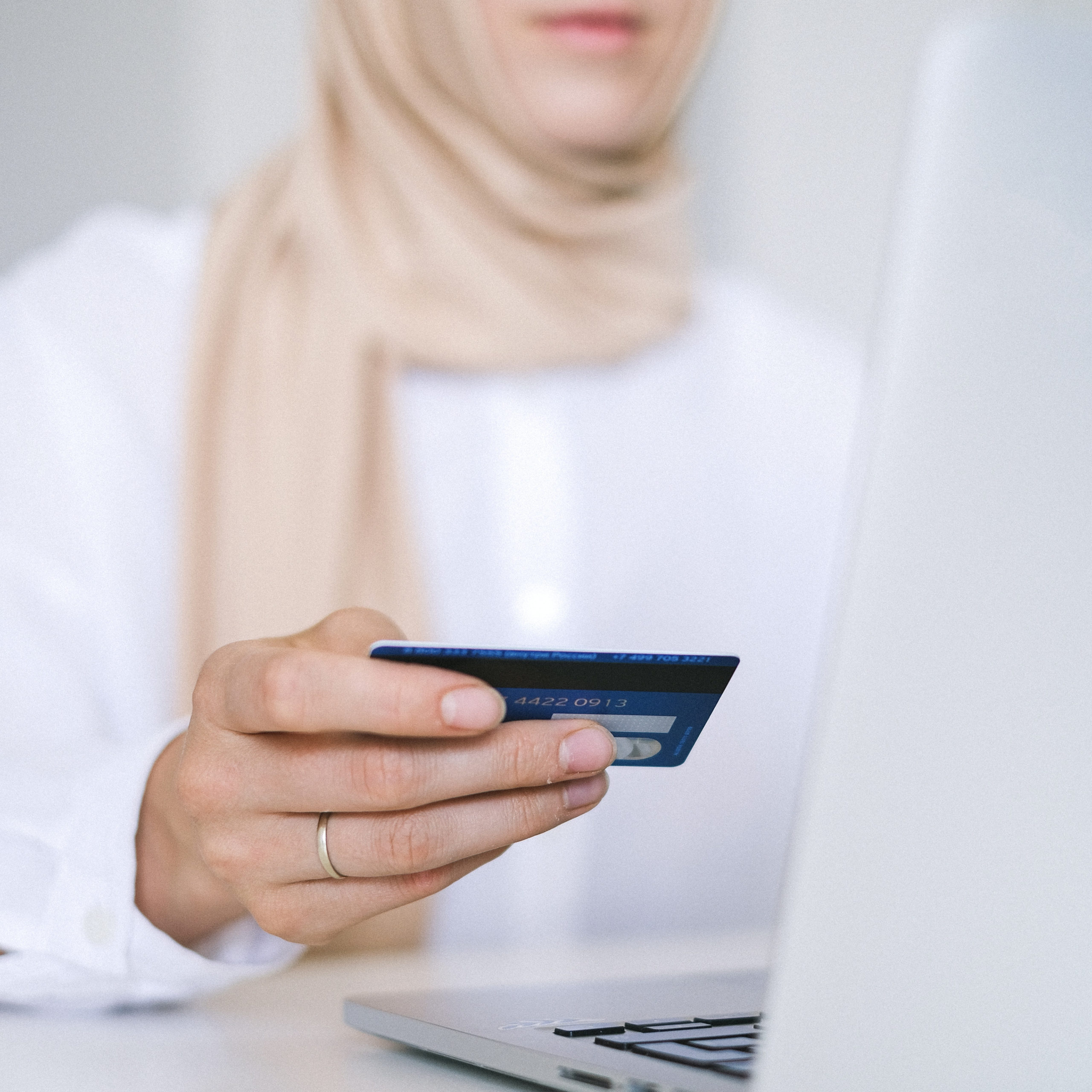 girl sitting on computer paying with a credit card
