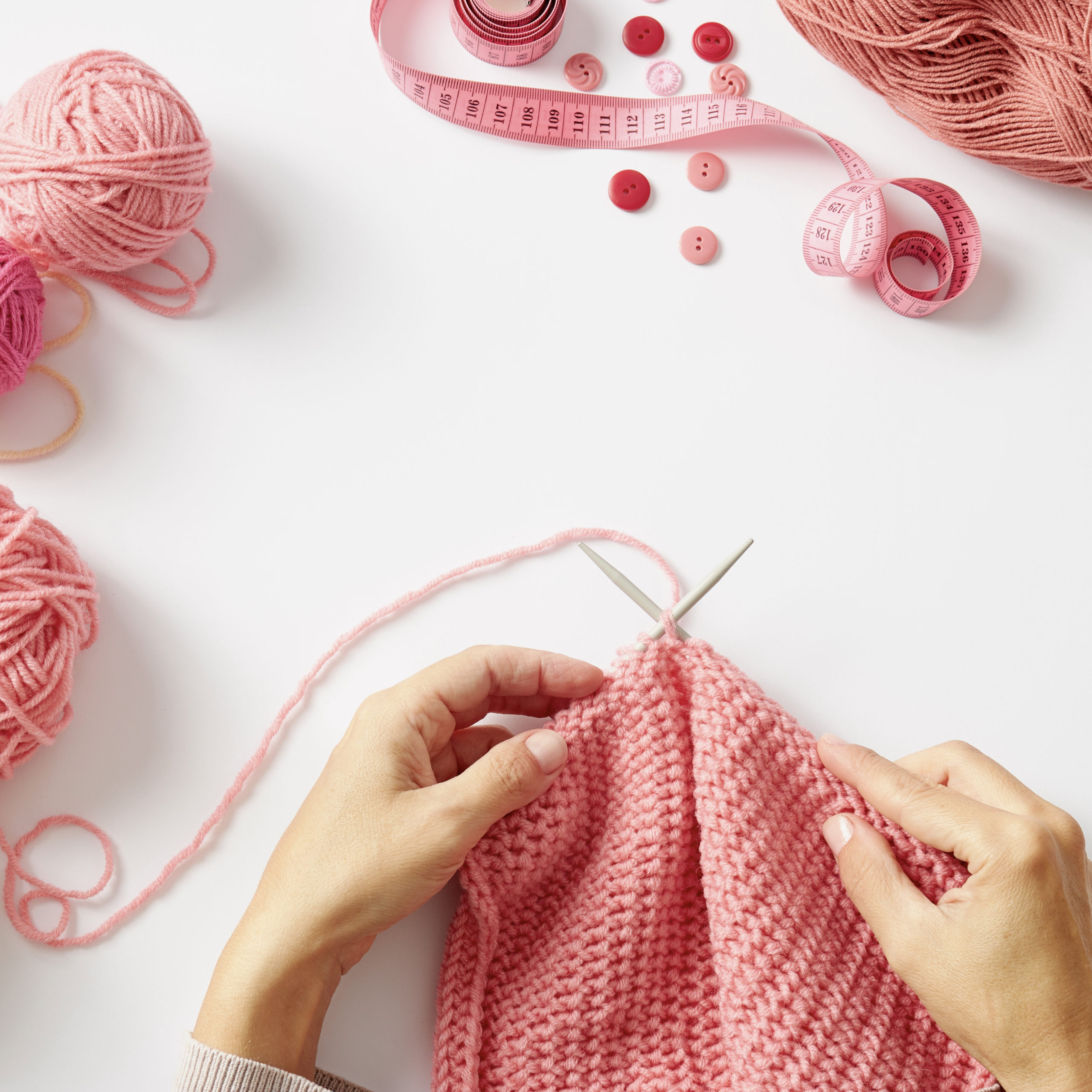 woman knitting with pink yarn | can crafting reduce anxiety | Positively Jane