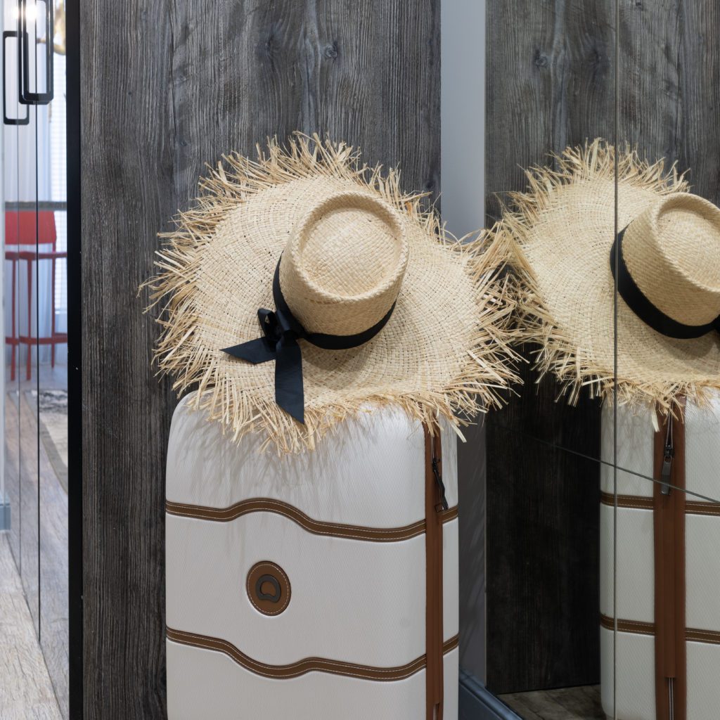2 white suitcases standing up and each have a straw hat on the handle | vacation packing checklist | Positively Jane  