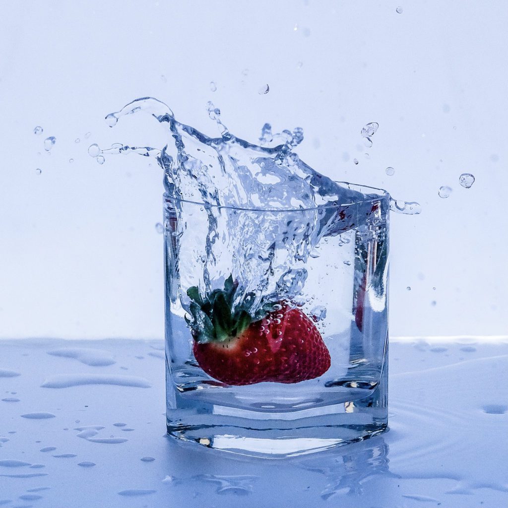 glass of water with a strawberry in it | 15 healthy daily habits | Positively Jane