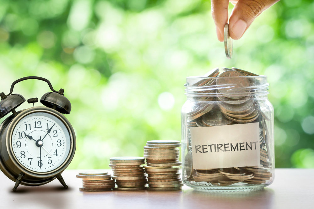 clock on the left. pile of coins in the middle. A jar with retirement written on the front. It has coins in it. A hand is above adding more coins | saving for retirement | Positively Jane