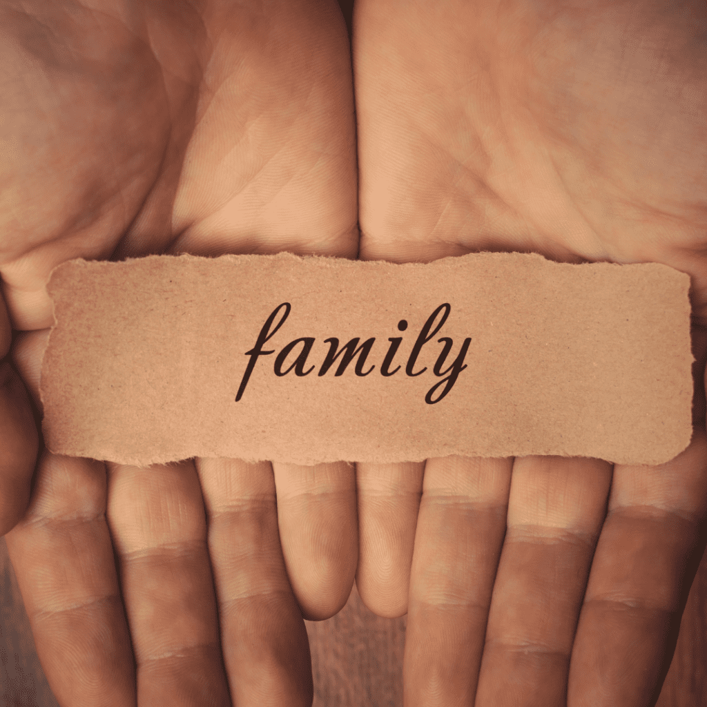 2 hands hold the word family