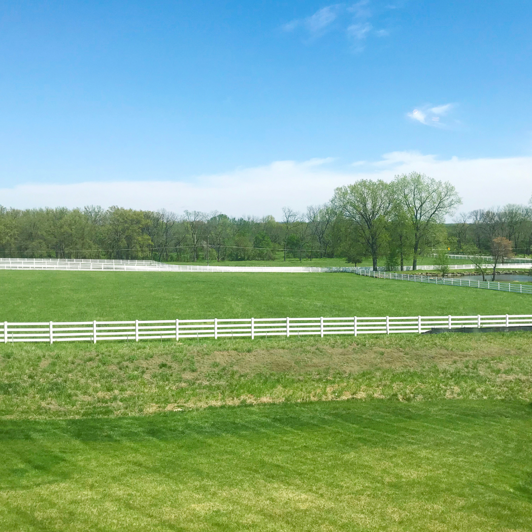 green field with a white fence | Home | Which Lot Should You Buy | positivelyjane