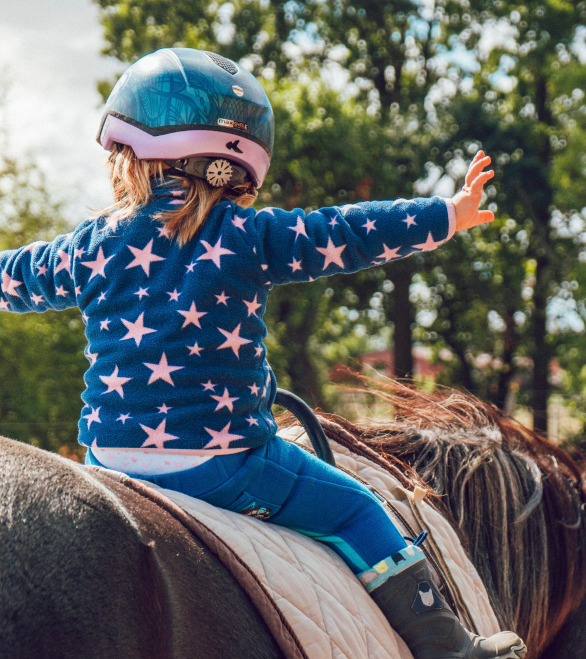 young girl sitting on a horse and not holding on