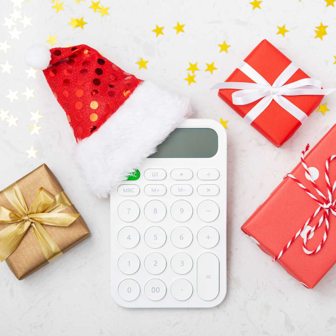 White calculator with a santa hat on surrounded by red and white colored wrapped gifts